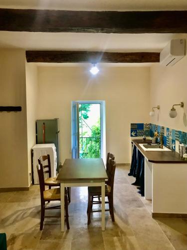 une cuisine et une salle à manger avec une table et des chaises dans l'établissement Appartement de village face à la rivière, à Lasalle