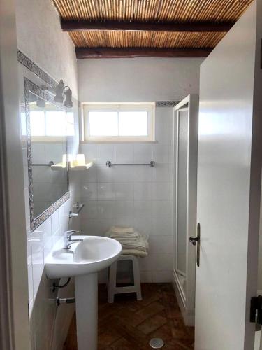 a white bathroom with a sink and a window at SOLAR DOS AVÓS in Guia
