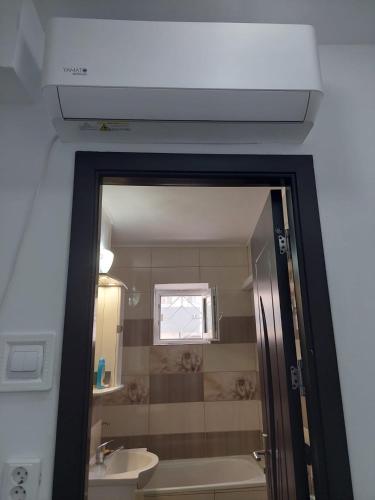 a bathroom with a shower and a sink and a mirror at Apartament Beatrice in Năvodari