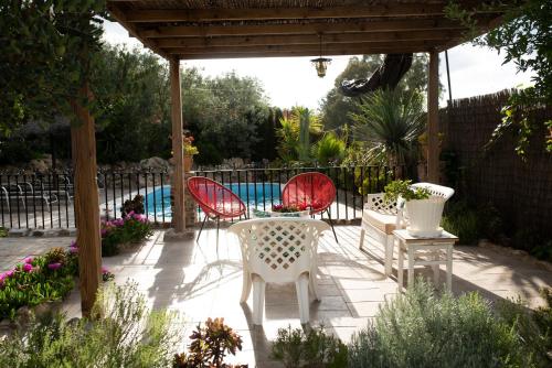 un patio con 3 sillas, una mesa y una piscina en Llano San Ignacio, en El Bosque
