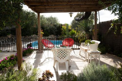 a patio with three chairs and a table and a pool at Llano San Ignacio in El Bosque