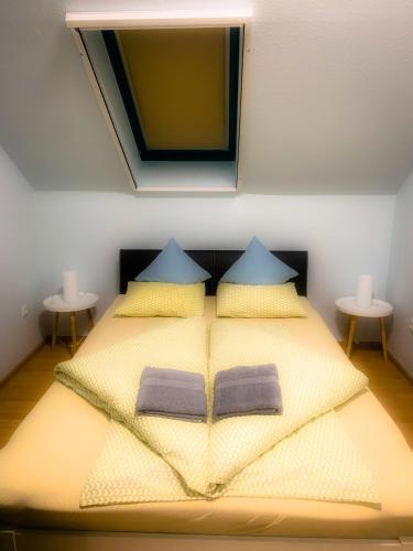 a bedroom with a bed with two pillows and a mirror at Rooftop Corner Siófok in Siófok