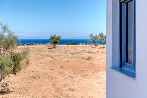 a window of a house with a view of the ocean at Chrysonisos Suites with Sunset & Seaviews near Kini in Ano Syros