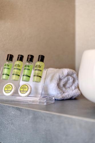 a group of four bottles of soap and a towel at Chrysonisos Suites with Sunset & Seaviews near Kini in Ano Syros