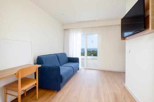 a living room with a blue couch and a television at Playamojácar in Mojácar