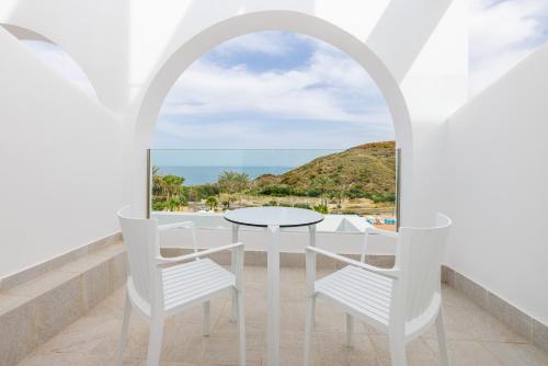 a balcony with a table and chairs and a view of the ocean at Playamojácar in Mojácar