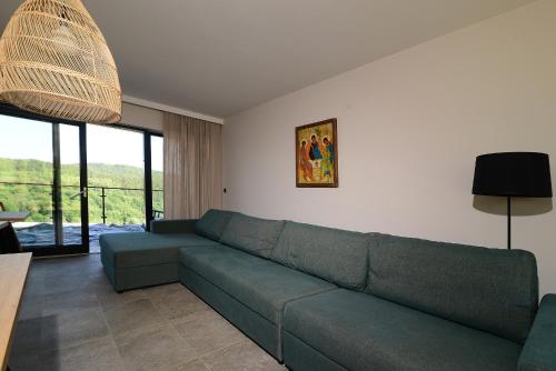 a living room with a green couch and a table at Skalnica - Apartamenty w Bieszczadach nad Soliną in Berezka