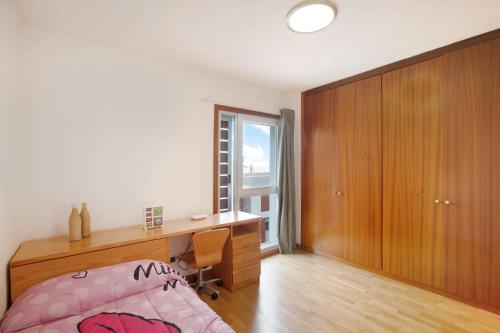 a bedroom with a desk and a bed with a pink bedspread at La Quinta Adosado in Santa Úrsula