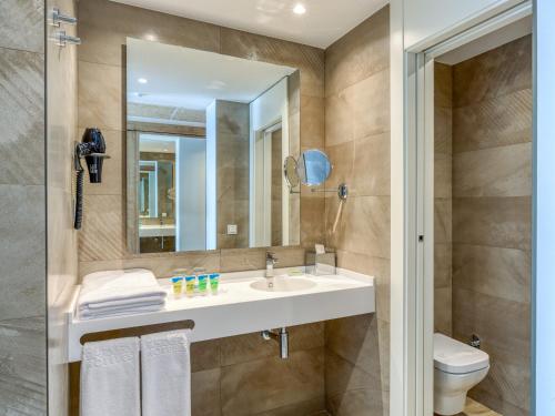 a bathroom with a sink and a toilet and a mirror at Playamojácar in Mojácar