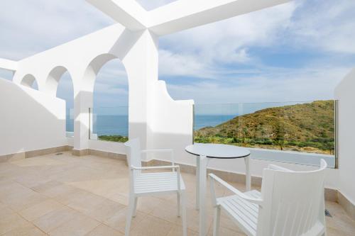 a white room with a table and chairs and the ocean at Playamojácar in Mojácar