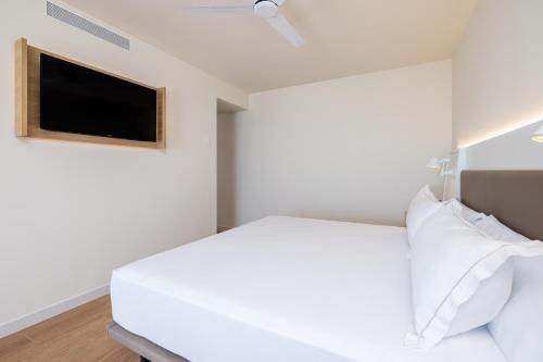 a bedroom with a bed and a flat screen tv at Playamojácar in Mojácar
