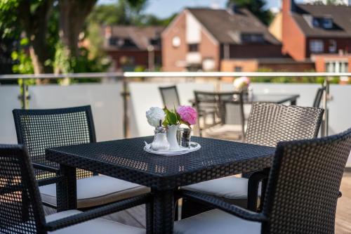 a black table with flowers on top of a balcony at Hotel Frechener Hof in Frechen