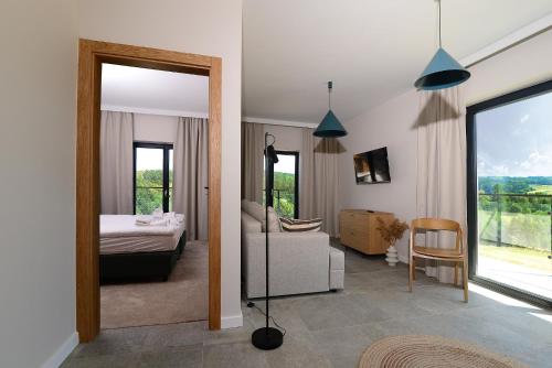 a bedroom with a bed and a living room at Skalnica - Apartamenty w Bieszczadach nad Soliną in Berezka