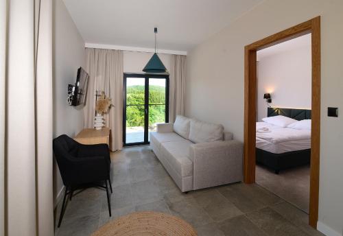 a bedroom with a bed and a couch and a chair at Skalnica - Apartamenty w Bieszczadach nad Soliną in Berezka