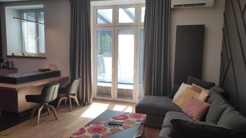 a living room with a couch and a table at Apartamenty Osmolice w Stawach in Dęblin