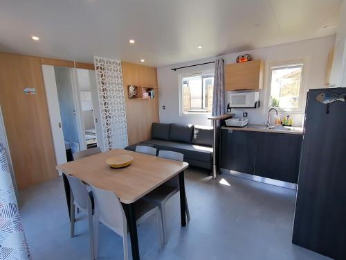 cocina y sala de estar con mesa y sofá en SAFRED Mobile Home Portbail-sur-Mer en Portbail