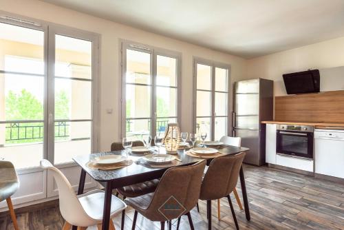 une cuisine et une salle à manger avec une table et des chaises dans l'établissement Central park Disneyland BMYGUEST, à Serris