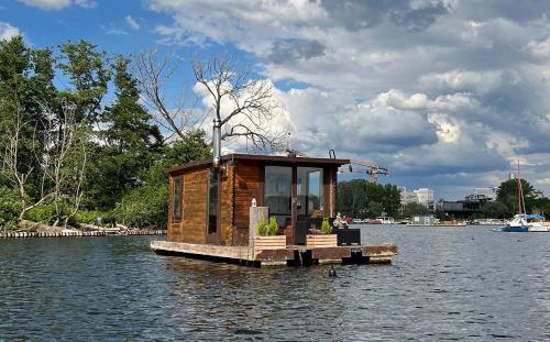 una pequeña cabaña en medio de un cuerpo de agua en Gemütliches Hausboot mit Kamin in Berlin, en Berlín