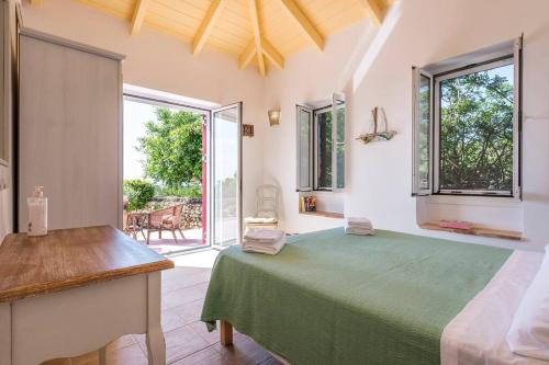 ein Schlafzimmer mit einem grünen Bett und einem großen Fenster in der Unterkunft Villa Zoi in Koríthion