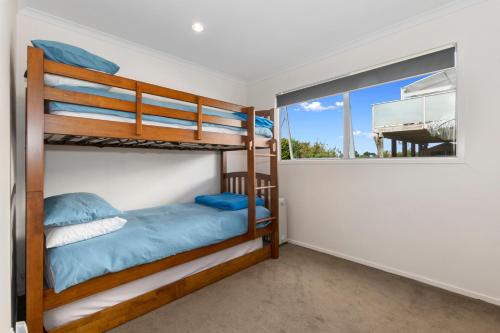 una camera da letto con letti a castello e una finestra di The Nautical Bach - Mangawhai Heads Holiday Home a Mangawhai