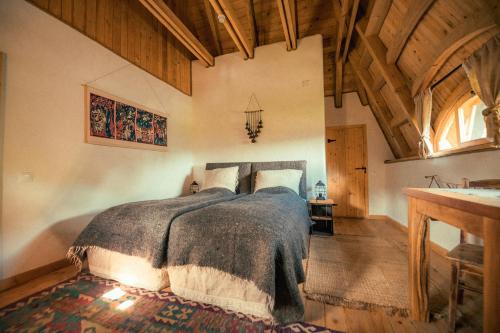 um quarto com uma cama num quarto com tectos em madeira em Raven's Nest - The Hidden Village, Transylvania - Romania em Sub Piatra