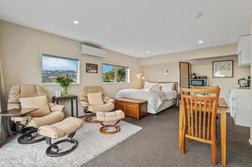 um quarto com uma cama, uma mesa e cadeiras em Gatehouse on the Bay - Christchurch Holiday Unit em Christchurch