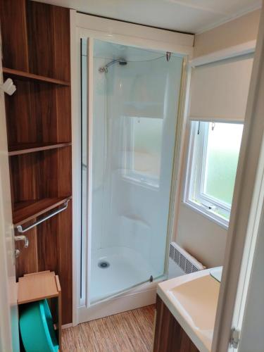 une salle de bain avec une douche avec une porte vitrée dans l'établissement Bungalow confortable à Angles avec piscine partagée, à Angles