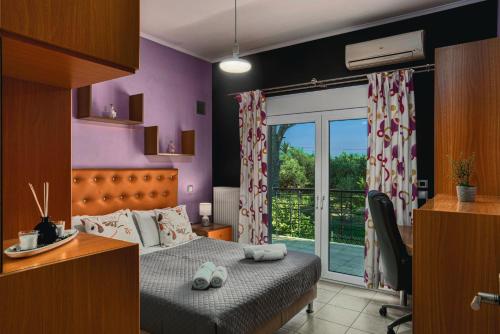 a bedroom with a bed and a desk and a window at Filios Villa in Zakynthos