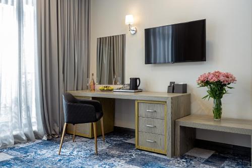 a hotel room with a desk and a tv on the wall at Sphera by Stellar Hotels, Yerevan in Yerevan