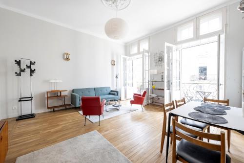 - un salon avec un canapé bleu et des fauteuils rouges dans l'établissement Place du Palais Centre Historique, à Bordeaux