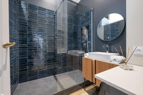 une salle de bain avec une douche, un lavabo et un miroir dans l'établissement Place du Palais Centre Historique, à Bordeaux