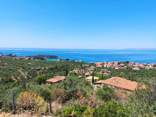 a village on a hill with the ocean in the background at Athina's Stone House in Kardamyli in Kardamili