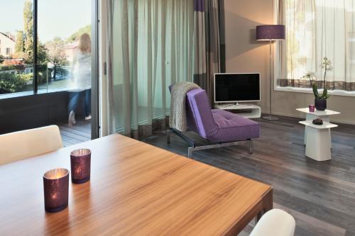a living room with a table and a purple chair at Limmathof Baden - Boutique Haus & Spa in Ennetbaden