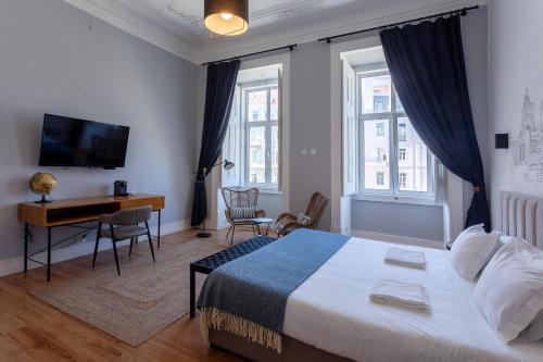 a hotel room with a bed and a desk and windows at Lisbon Check-In Guesthouse in Lisbon