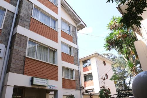a building in the city with a palm tree at Adventist LMS Guest House & Conference Centre in Nairobi
