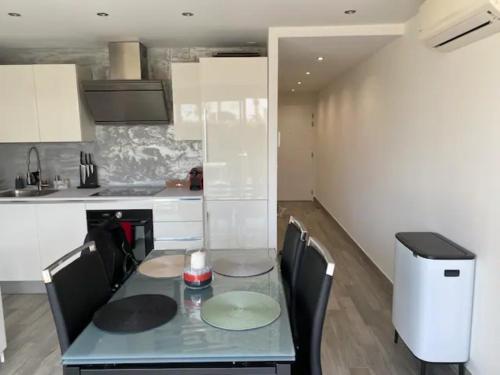 a kitchen with a table and chairs in a kitchen at LE PLEIN SUD A DEUX PAS DE LA PLAGE in Saint-Cyr-sur-Mer