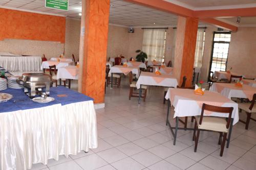 a dining room with tables and chairs with white table cloth at Adventist LMS Guest House & Conference Centre in Nairobi
