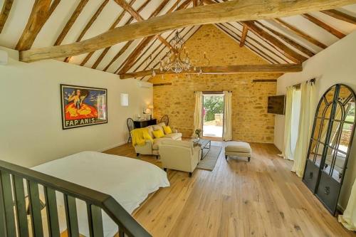 a bedroom with a bed and a living room at Par La Rivière in La Roque-Gageac
