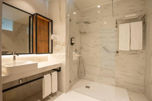 a white bathroom with a sink and a shower at Vila Luz in Luz