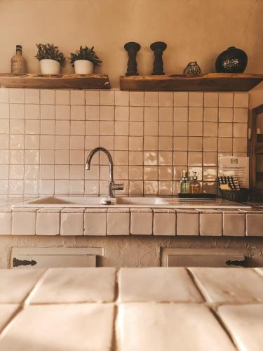 Il dispose d'une cuisine avec un évier et un mur carrelé. dans l'établissement Le Mouron Rouge, à La Garde-Freinet