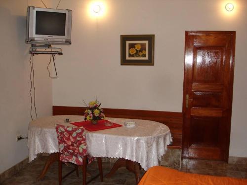 Habitación con mesa y TV en la pared. en Swiss Chalet with Private Kitchen near Lima en Canta