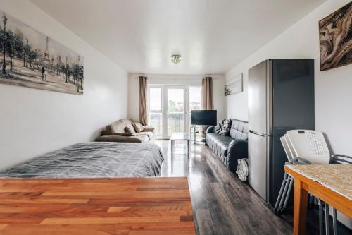 - une chambre avec un lit et un canapé dans l'établissement Lloyd St Apartment, à Manchester