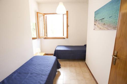 a small room with two beds and a window at Villa Conti Residence in Lacona