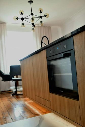 a kitchen with a black oven and a table at APARTAMENT GRODZKA1, 100 m2 przy przemyskim rynku z widokiem na rynek i panoramę miasta in Przemyśl