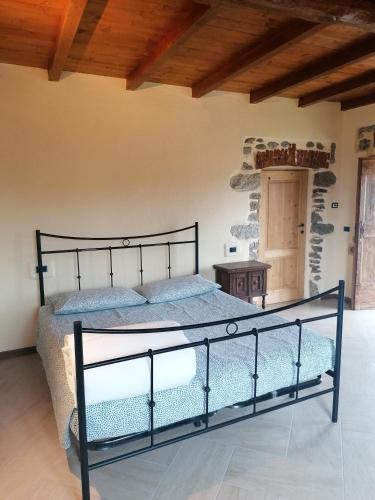 a bedroom with a black bed in a room at BeB LORTALLINO in Ameno