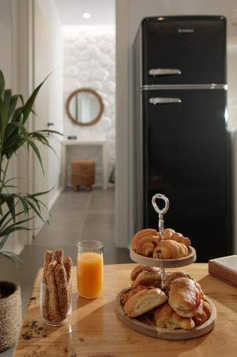 a table with two plates of food and a glass of orange juice at Kamvas Deluxe Apartments in Naxos Chora