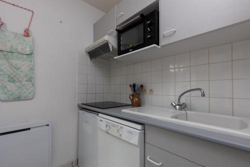 une cuisine avec un évier et un plan de travail dans l'établissement Piot T2 200m de la Plage, à Moliets-et-Maa