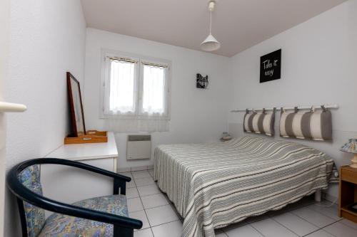 une chambre avec un lit et une chaise dedans dans l'établissement Piot T2 200m de la Plage, à Moliets-et-Maa