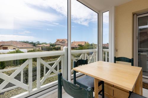 une table et des chaises sur un balcon avec vue dans l'établissement Piot T2 200m de la Plage, à Moliets-et-Maa