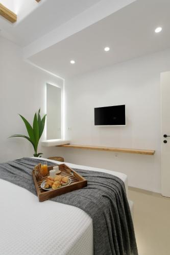 a tray of food sitting on top of a bed at Kamvas Deluxe Apartments in Naxos Chora